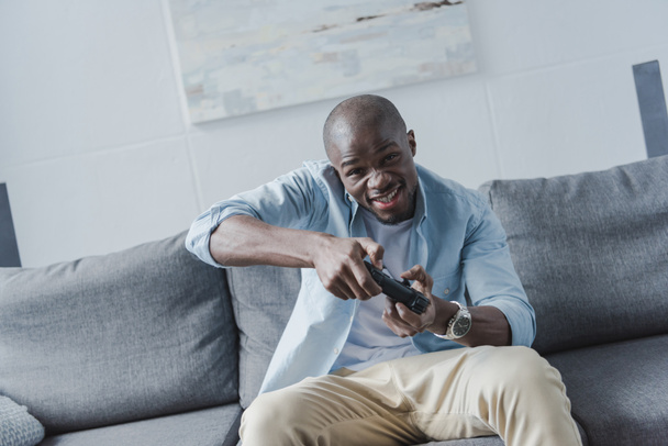 Αφρικανική αμερικανική άνθρωπος που παίζει με joystick - Φωτογραφία, εικόνα