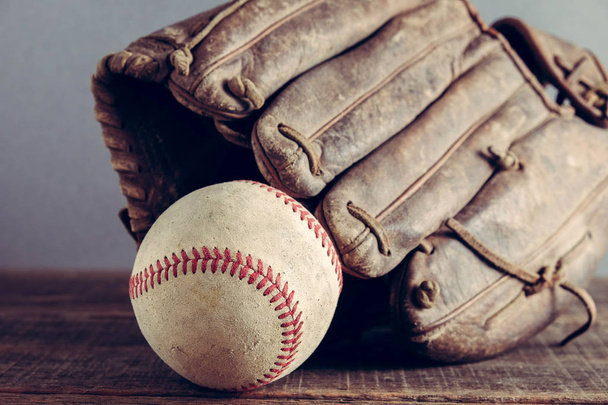 old Baseball and glove on wood background with filter effect retro vintage style - Foto, afbeelding
