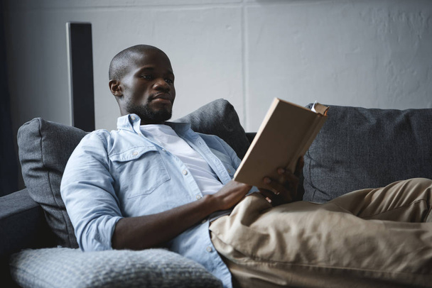 african american man reading book  - Foto, Bild