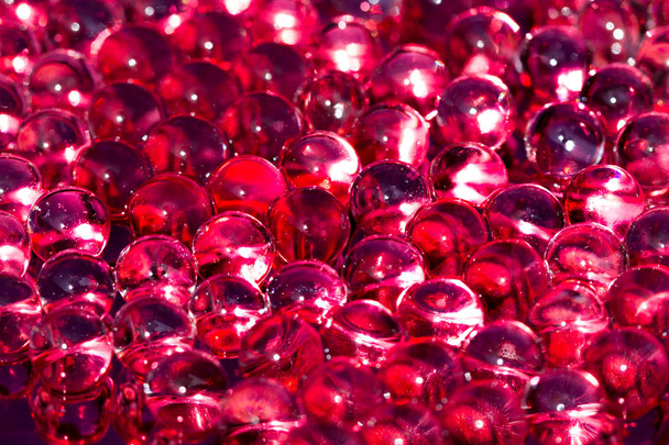 Червоні блискучі водяні гелеві кульки. Макро фотографія, може бути використана як для реклами, так і для косметики, ювелірних виробів і для медицини. Абстрактний фон
. - Фото, зображення