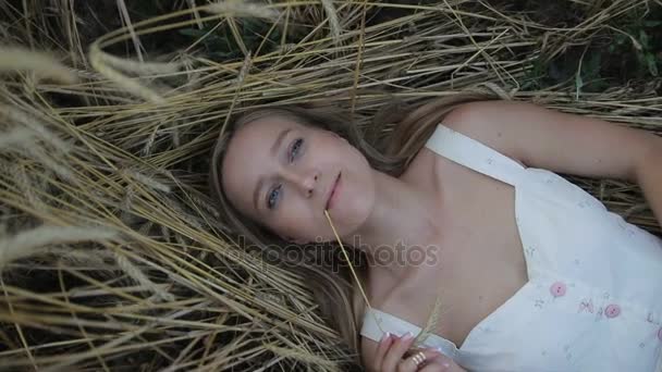 Мрійлива дівчина лежить на золотому стиглому пшеничному полі
 - Кадри, відео