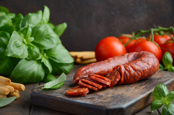 Chorizo sausage. Spanish traditional chorizo sausage with fresh herbs and tomatoes. - Photo, image