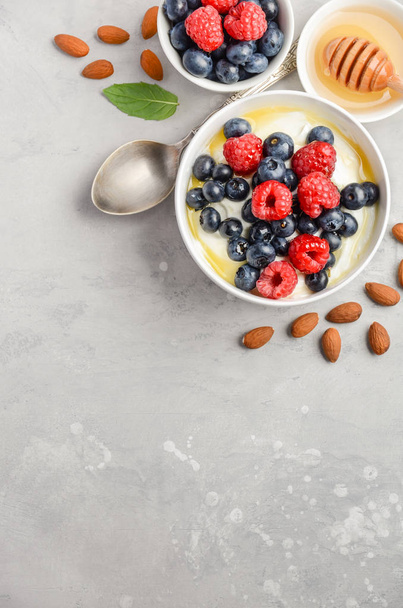 Natural yogurt with fresh berries and honey, healthy breakfast concept - Photo, Image