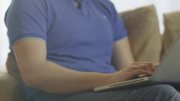 Homem deitado no sofá e usando laptop em casa
 - Filmagem, Vídeo