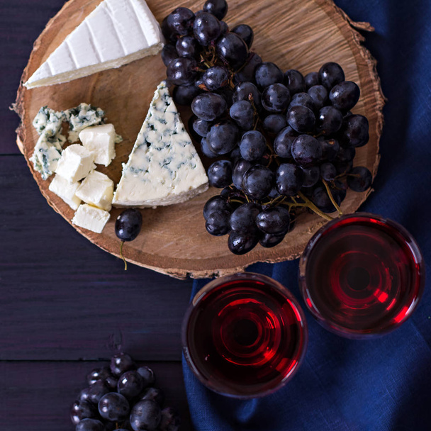 Red wine and snacks. Wine, grapes, cheese, nuts, olives. Romantic evening, still life. - Photo, Image