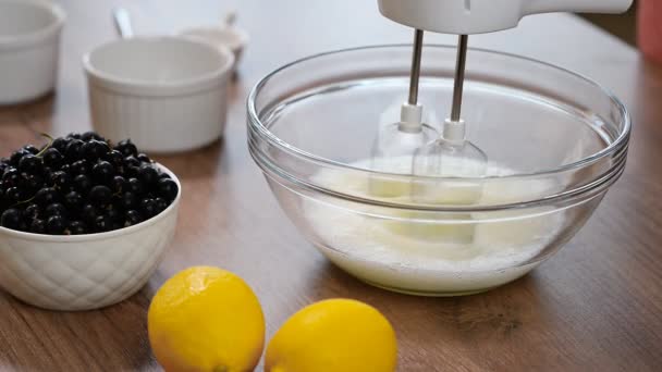 Woman whisking eggs whites with mixer into glass bowl. To make the meringue - Footage, Video