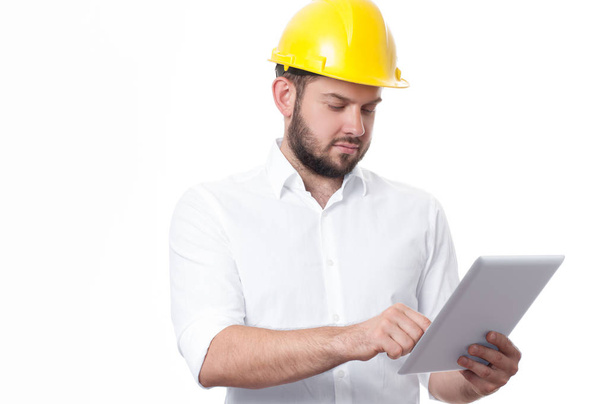 Contractor in yellow builder helmet working on a project with tablet.  - Fotó, kép
