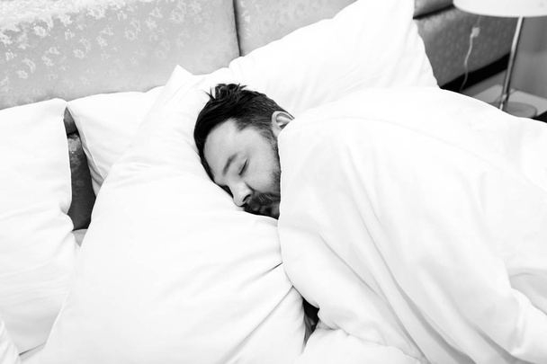 Attractive bearded young man sleeping in bed at home - Foto, Imagen