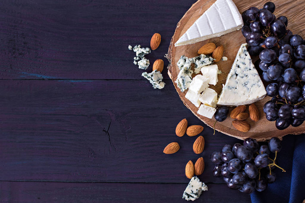 Snacks to wine. Grapes, cheese, nuts, olives. - Fotografie, Obrázek