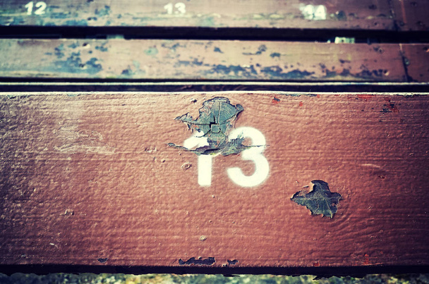 Номер тринадцать, нарисованный на старом деревянном сидении.
. - Фото, изображение