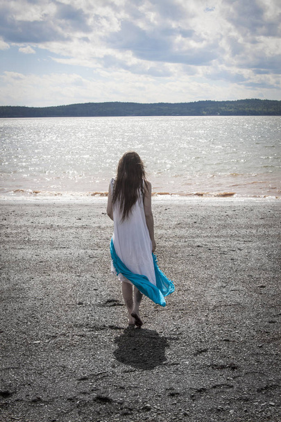 Woman strolling along Black Beach, Lorneville, New Brunswick, in - Photo, Image