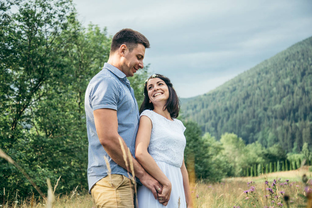 couple in love walking in feild with beautiful view on moutains - Photo, Image
