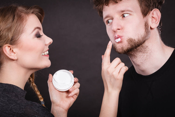 Female beautician apply cream on male mouth. - Foto, Bild