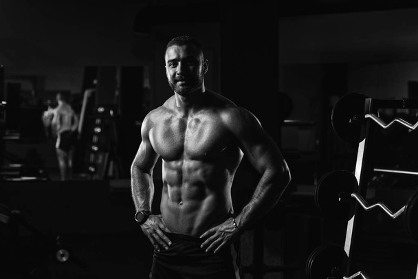 Muscular Man Flexing Muscles In Gym - Foto, afbeelding