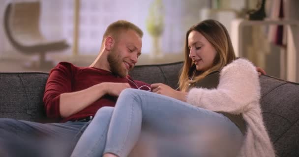 Cool couple listening to music on smartphone - Materiał filmowy, wideo