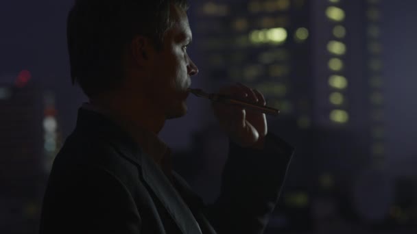 Businessman is Smoking Electronic Cigarette at Evening - Felvétel, videó