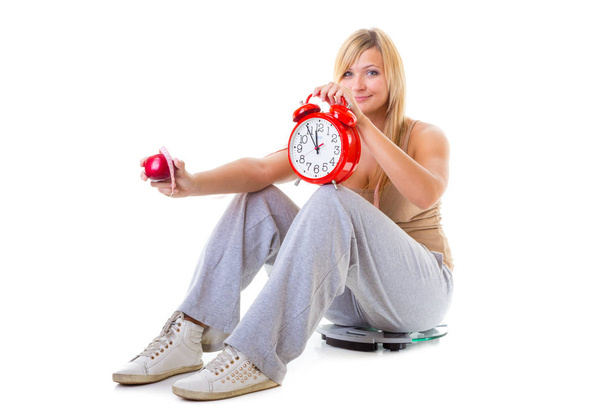 Woman holding apple, measuring tape and clock - Foto, Imagem