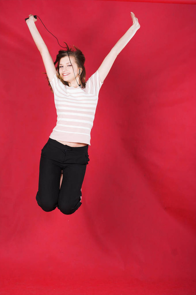 girl jumping of joy over red - Zdjęcie, obraz