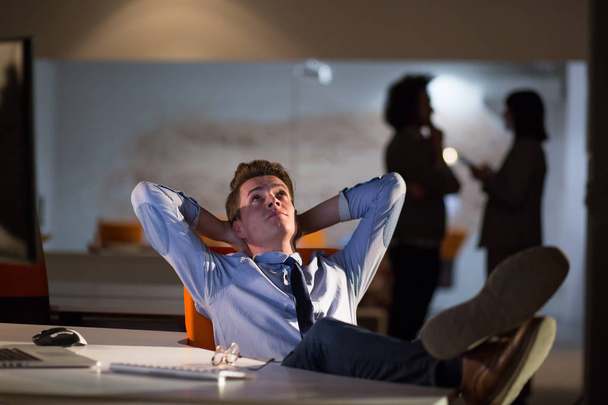 businessman sitting with legs on desk at office - Foto, Bild