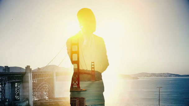 Dubbele blootstelling van San Francisco Golden Bridge en zakenman aan de telefoon - Video