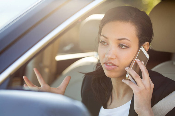 Business woman talking on her mobile phone and driving. - Foto, imagen