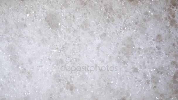 white foam bubbles at the washing machine, close up top view for your background - Footage, Video