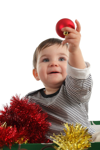 Baby inside a box showing a christmas ball - Photo, Image