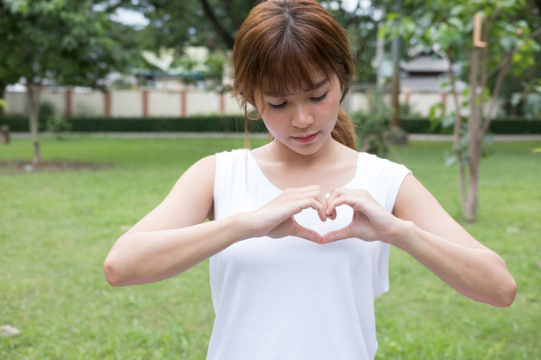 mujer joven haciendo un gesto de corazón con los dedos. chica asiática
  - Foto, imagen
