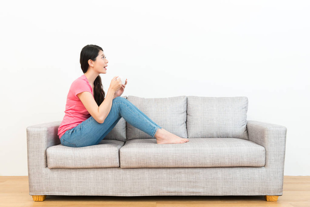 cheerful smiling woman sitting on sofa relaxing - Photo, image