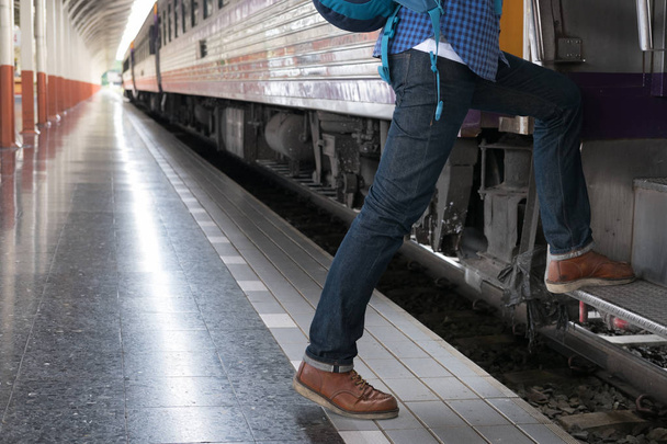 young man, tourist or traveler stepping up to the train on railw - Valokuva, kuva