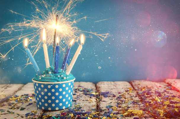 Birthday concept with cupcake and candles on wooden table - Foto, afbeelding