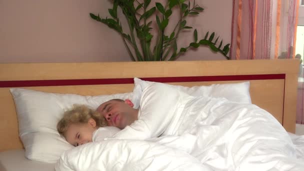 Lovely child girl with bald head man father wake up in morning at bedroom - Footage, Video