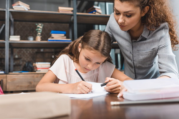 mother and daughter doing homework together - Photo, Image