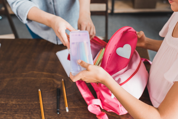 mother and daughter preparing backpack for school - Photo, Image