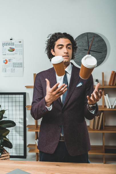 zakenman jongleren met wegwerp bekers - Foto, afbeelding