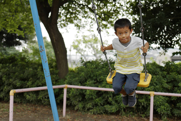 Ιαπωνικό αγόρι με την κούνια (δεύτερου βαθμού στο Δημοτικό σχολείο) - Φωτογραφία, εικόνα
