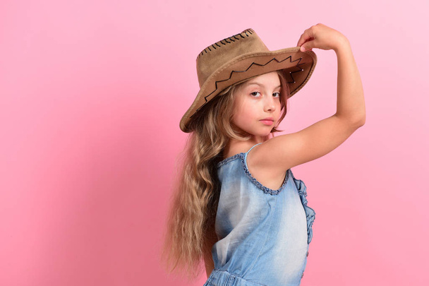 Girl in fancy outfit holds cowboy hat - 写真・画像