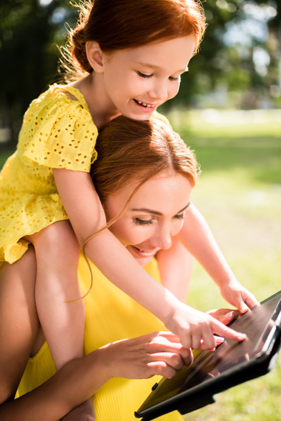 mother and daughter with gadget in park - Foto, Bild