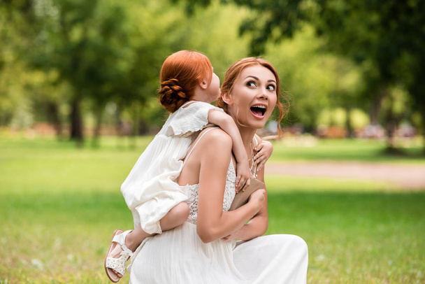 mother piggybacking daughter in park - Photo, image