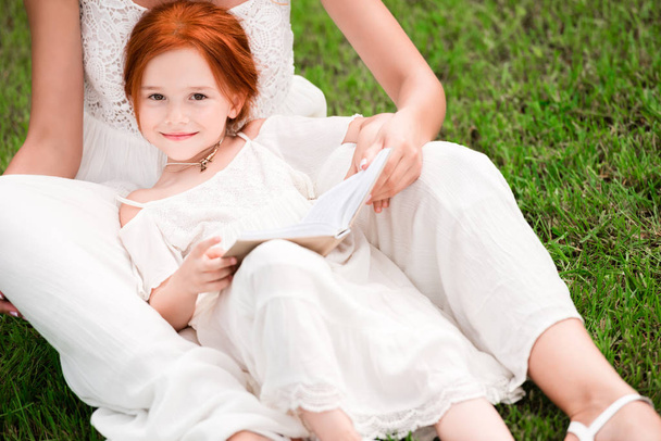 mother and daughter with book at park - Foto, Imagen