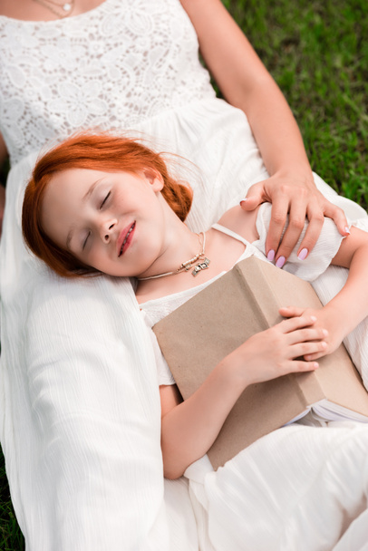 mother and daughter with book at park - Photo, Image