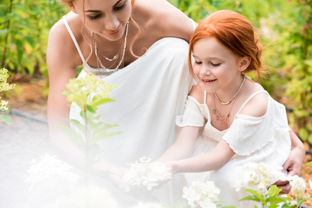 mother and daughter with flowers   - Фото, изображение