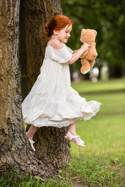 girl with teddy bear in park - Zdjęcie, obraz