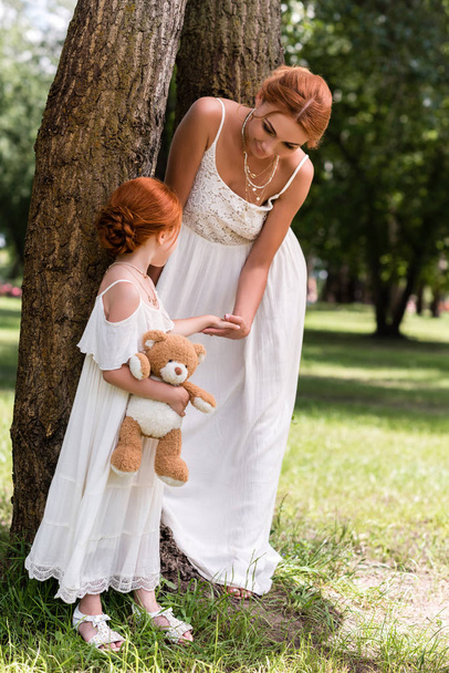 mother and daughter with teddy bear in park - Foto, Bild