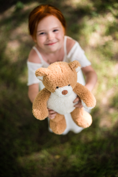 meisje met teddybeer in park - Foto, afbeelding