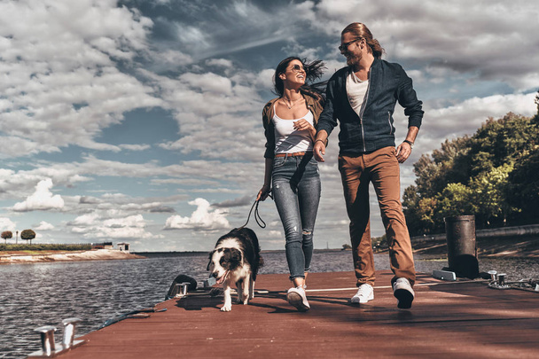 beautiful couple walking with dog - Fotó, kép