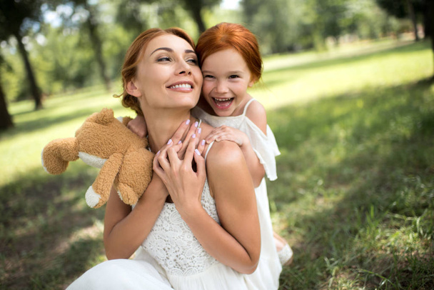 mother and daughter hugging in park - Photo, Image