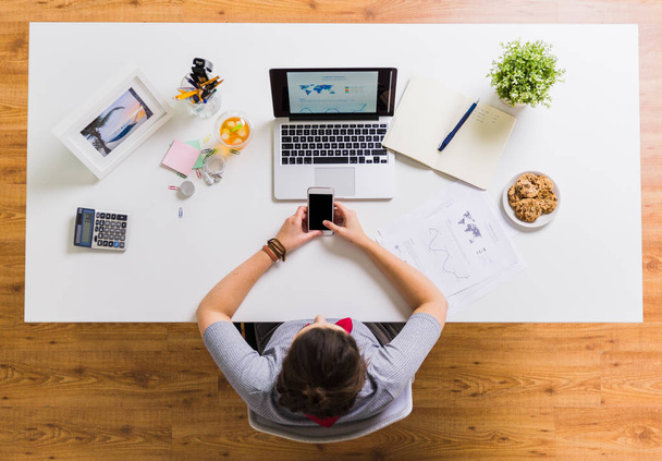 mulher com smartphone e laptop na mesa de escritório
 - Foto, Imagem