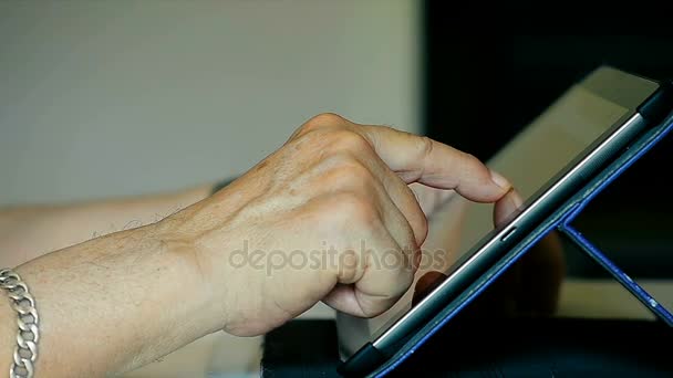 Close-Up vecchie mani della persona anziana utilizzando IPad Tablet a casa
 - Filmati, video