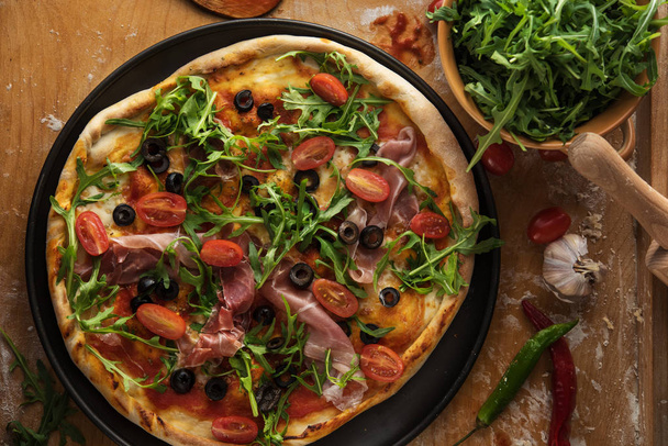Traditional pizza with prosciutto and arugula - Фото, зображення